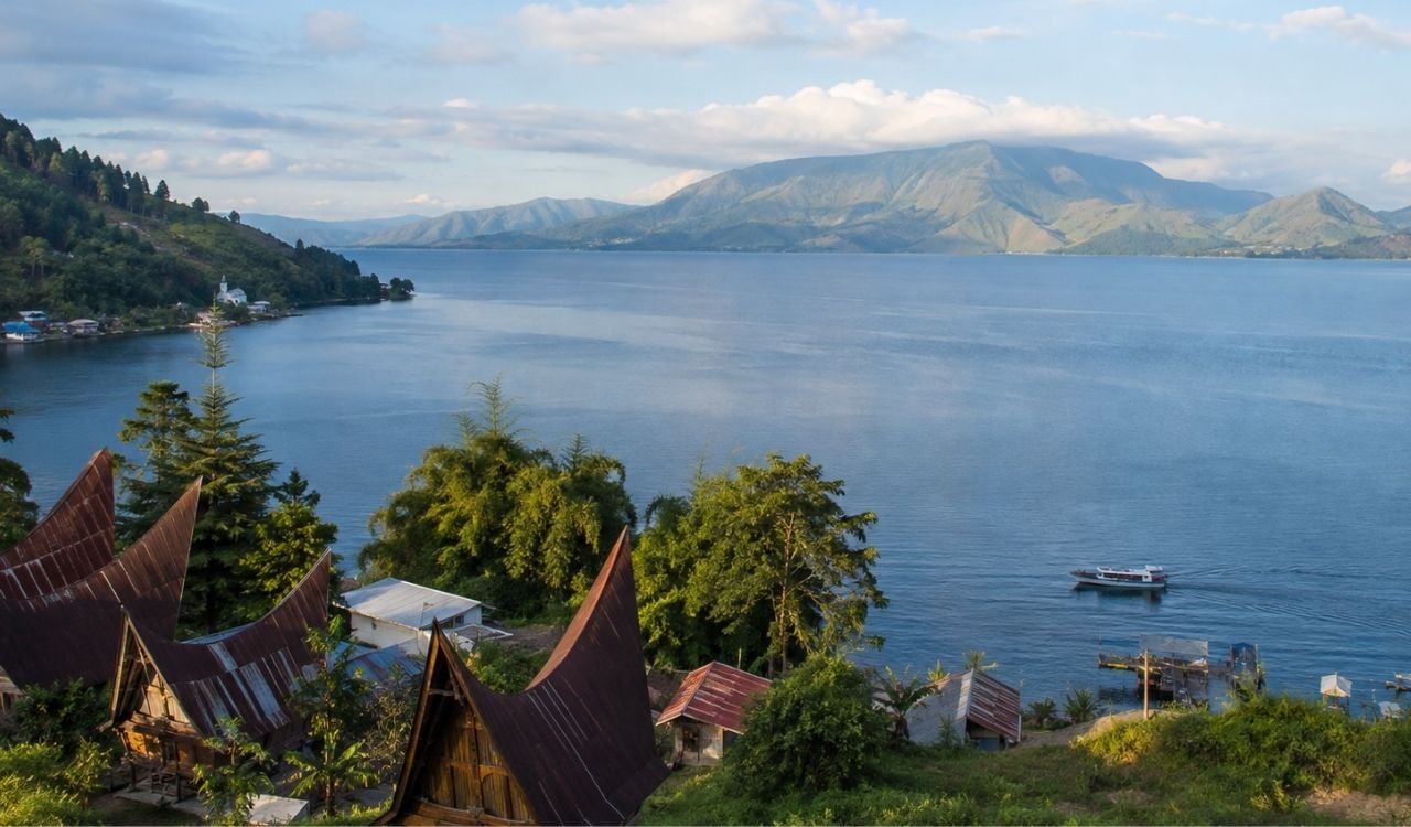 Lake Toba overlooking Samosir Island, traditional Batak houses and a boat in North Sumatra, Indonesia