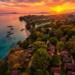 Aerial sunset view of Phi Phi Islands with turquoise sea, tropical trees, beach and traditional boats in Thailand