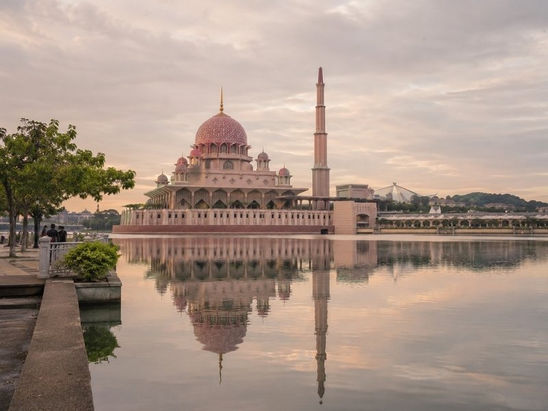 Putra Mosque in Putrajaya reflected in the lake beneath a soft evening sky