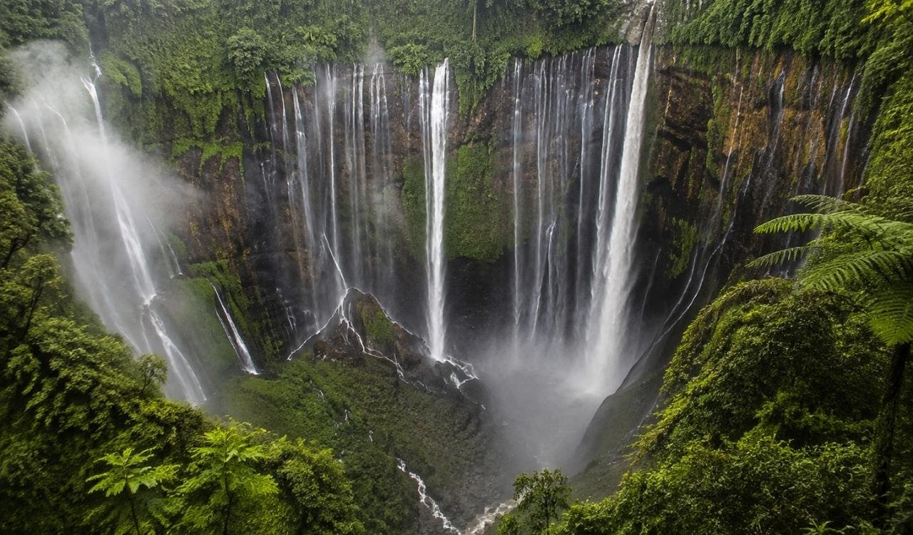 Tumpak Sewu Waterfall cascading into a lush tropical canyon in East Java, Indonesia