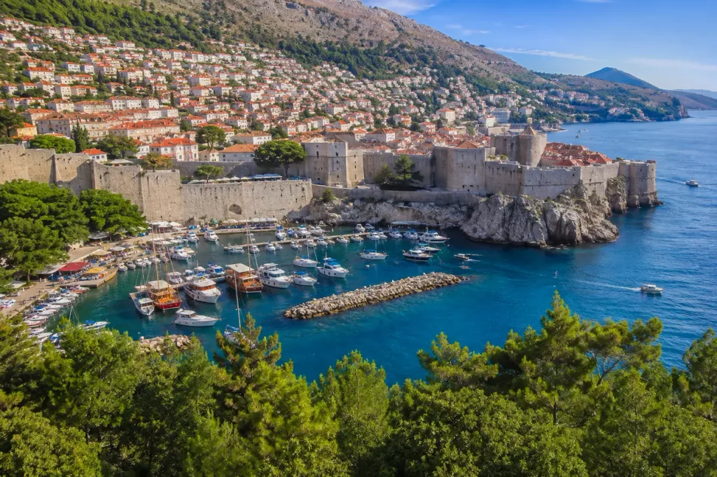 Dubrovnik Old Port, historic city walls and red-roofed buildings.