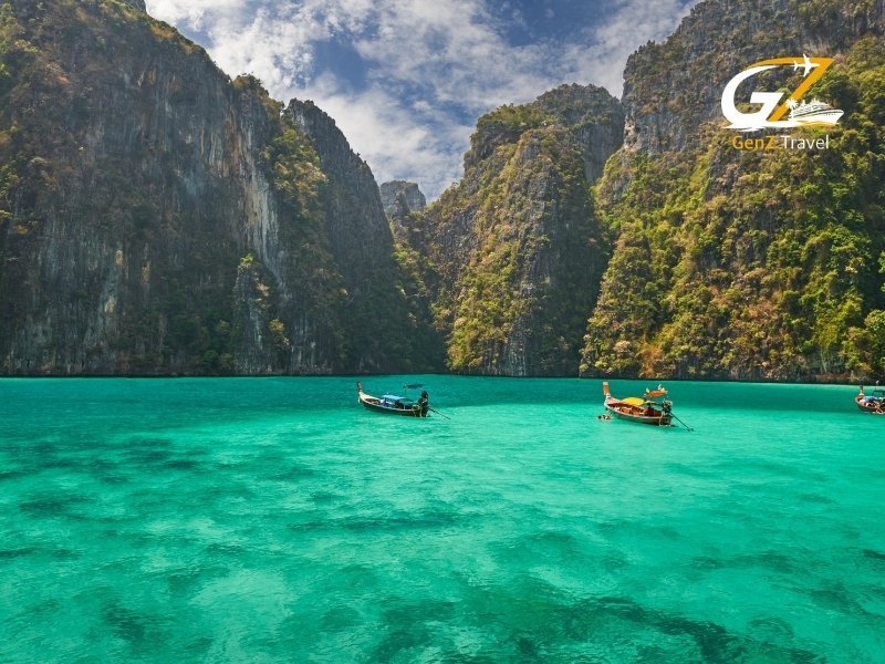 Scenic view of Phi Phi Islands limestone cliffs rising above crystal clear turquoise waters with boat in foreground