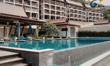 Luxury resort swimming pool in Phuket surrounded by palm trees and tropical greenery