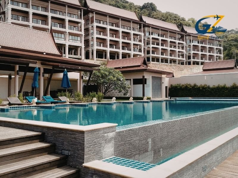 Luxury resort swimming pool in Phuket surrounded by palm trees and tropical greenery