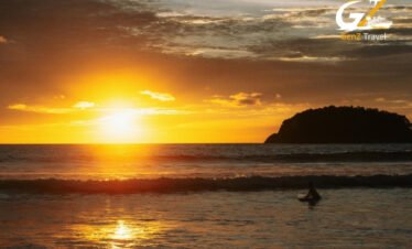 Stunning sunset over a tropical beach in Phuket with golden skies and calm turquoise water