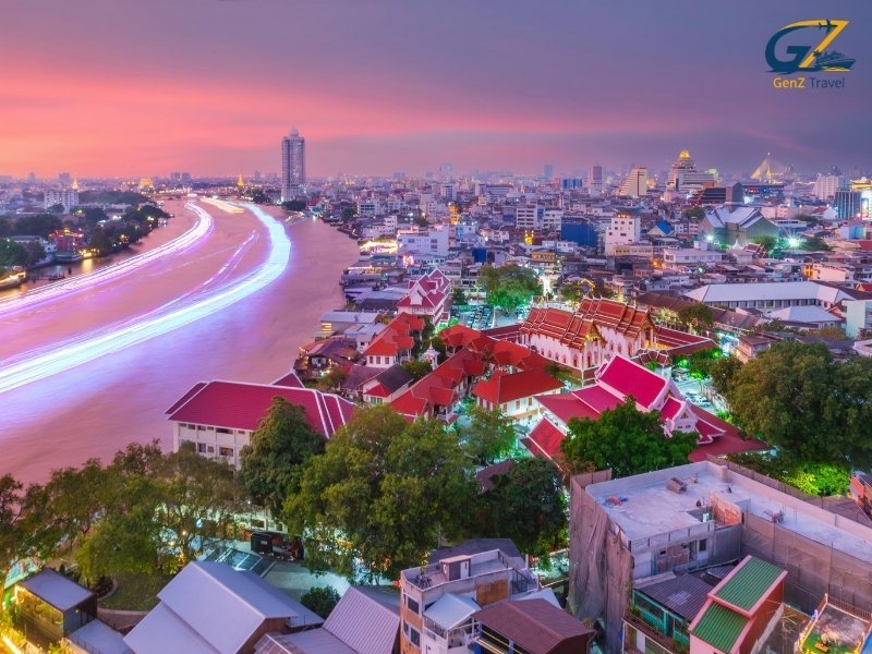 Modern luxury hotel suite overlooking Bangkok skyline at night with glowing city lights and river view