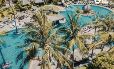 Luxury all-inclusive poolside bar in Cancun with palm trees and ocean view for UK holiday package