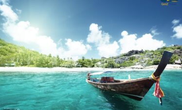 Crystal clear turquoise water at Coral Island near Pattaya with white sand beach and tropical boats