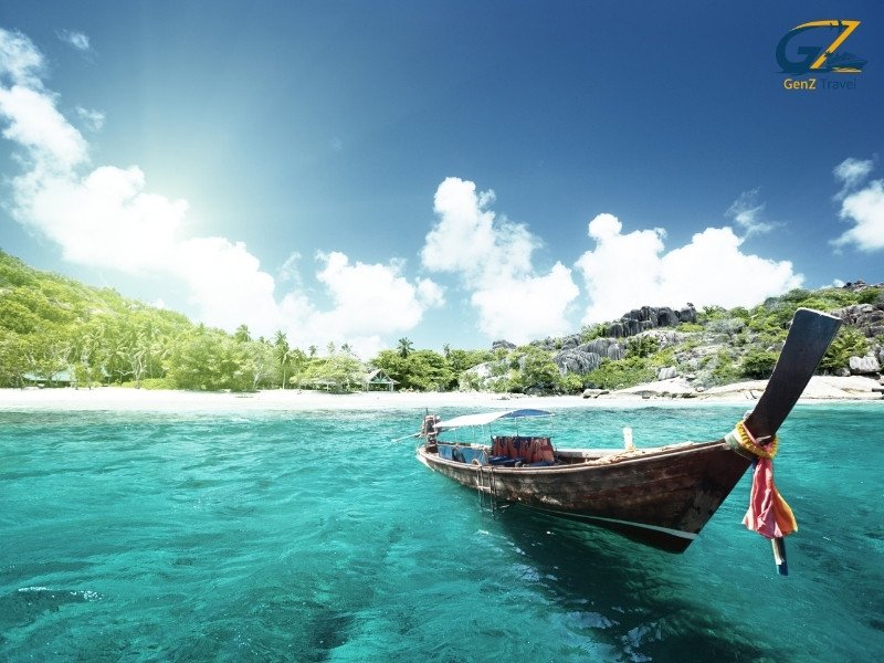 Crystal clear turquoise water at Coral Island near Pattaya with white sand beach and tropical boats