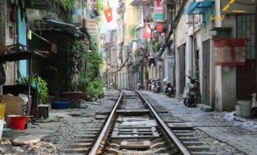 Hanoi Old Quarter street life with scooters and local food stalls Vietnam tour package