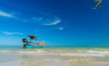 Calm beachfront resort in Khao Lak with golden sunset, palm trees and peaceful ocean waves