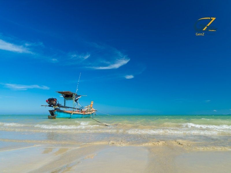 Calm beachfront resort in Khao Lak with golden sunset, palm trees and peaceful ocean waves