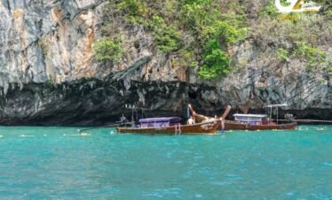 Krabi Ao Nang beach with traditional longtail boats and limestone cliffs Thailand