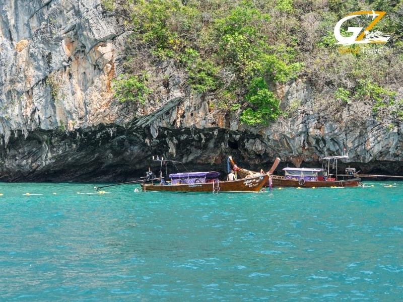 Krabi Ao Nang beach with traditional longtail boats and limestone cliffs Thailand