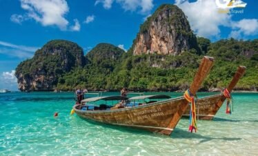 Krabi limestone cliffs with longtail boats and turquoise water Thailand