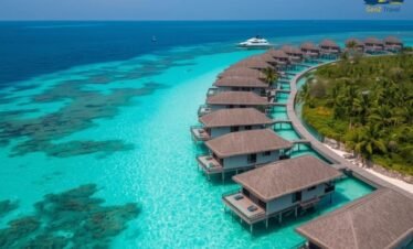 Overwater villas in Malaysia at sunset with wooden decks and ocean views over the Strait of Malacca