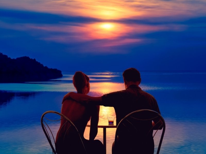 Couple walking on Maldives beach at sunset romantic luxury holiday