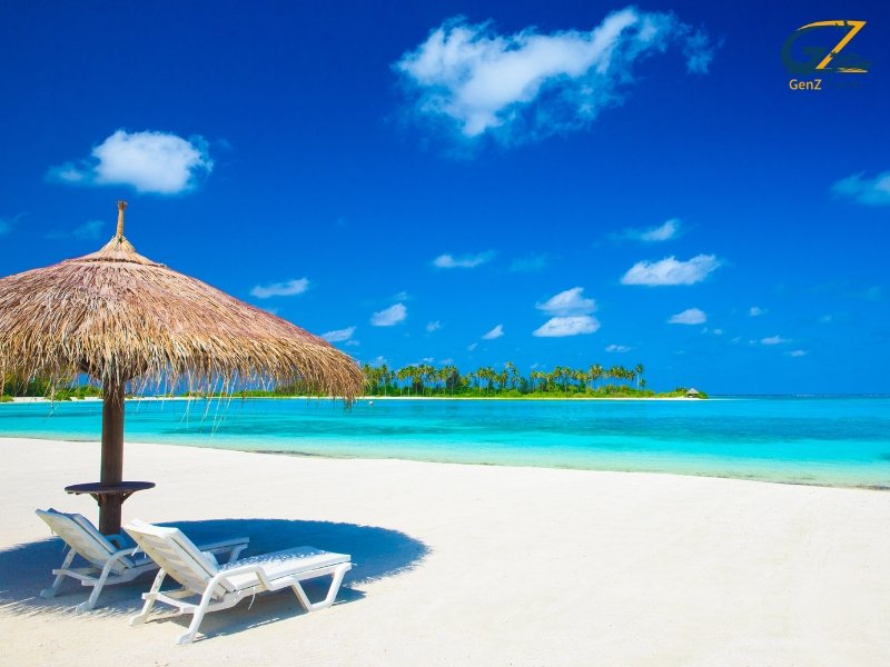 tropical Maldives sandbank surrounded by clear blue ocean under bright sunny sky