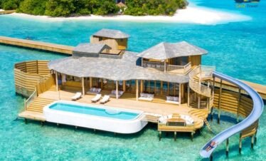 Maldives water villa with private pool and slide at Siyam World over clear lagoon