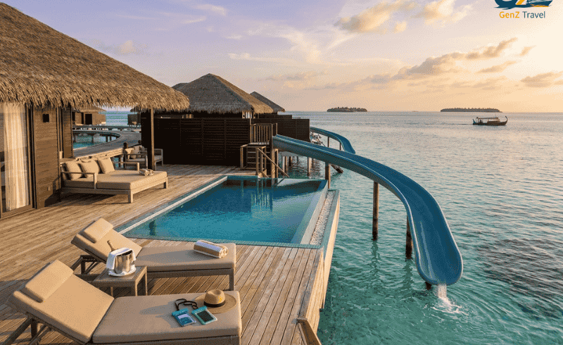 Maldives water villa with private pool and slide at Siyam World resort over turquoise lagoon