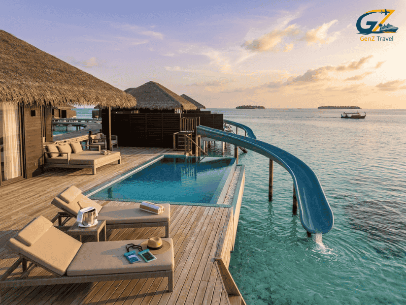Maldives water villa with private pool and slide at Siyam World resort over turquoise lagoon