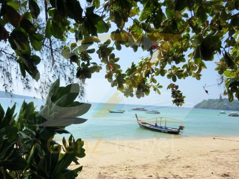 Thailand holidays from UK showing Phuket beach with traditional longtail boat