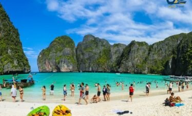 Phuket beach with turquoise water and traditional longtail boats in Thailand tour package from UK