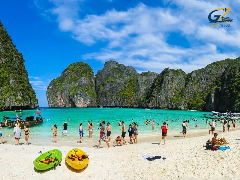 Phuket beach with turquoise water and traditional longtail boats in Thailand tour package from UK