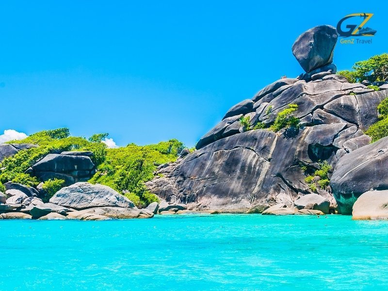 Crystal clear water at Similan Islands with snorkelling tourists and vibrant coral reef scenery