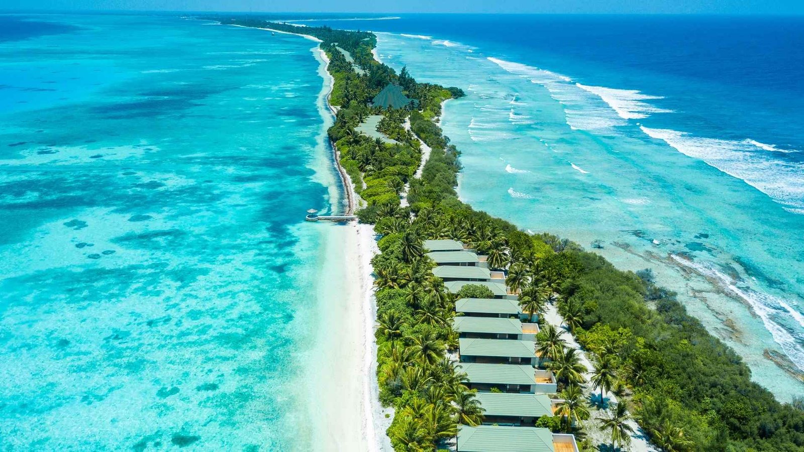Aerial view of Canareef Resort Maldives with overwater villas, turquoise lagoons, and lush tropical greenery.