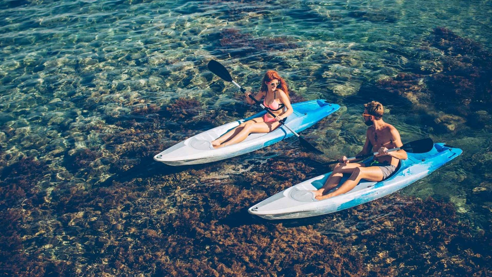 Guests enjoying water sports and spa facilities at Canareef Resort Maldives surrounded by turquoise waters.
