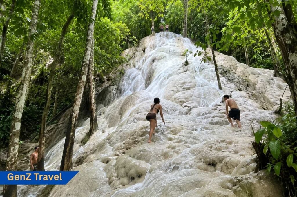 Sticky Waterfall Bua Tong near Chiang Mai with travellers climbing limestone rocks in the jungle