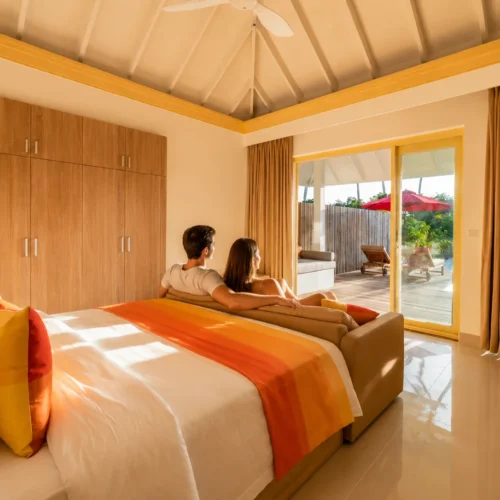 UK couple relaxing inside a bright bedroom at Siyam World Maldives Sunset Pool Beach Villa