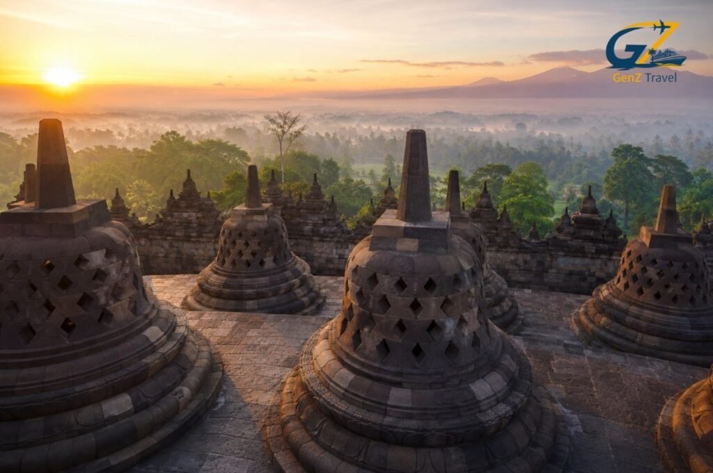 Borobudur Temple stupas at sunrise overlooking lush Central Java landscape in Indonesia