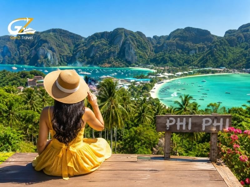 Woman overlooking the best places to stay in Phi Phi, with turquoise bays, longtail boats and limestone cliffs.