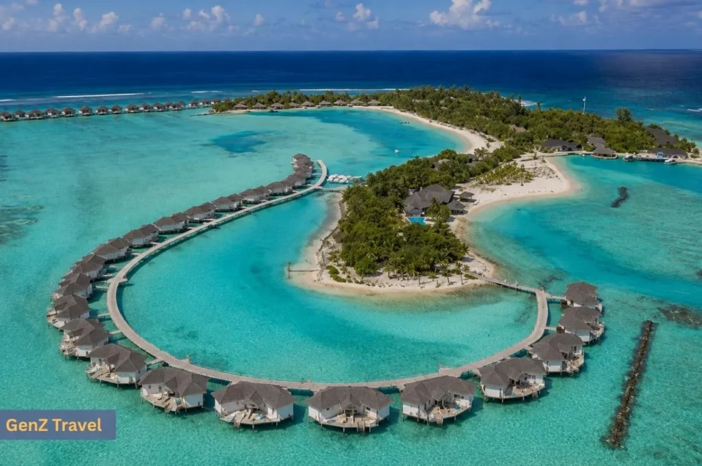 Aerial view of Cinnamon Dhonveli Maldives with curved overwater villas surrounding a turquoise lagoon