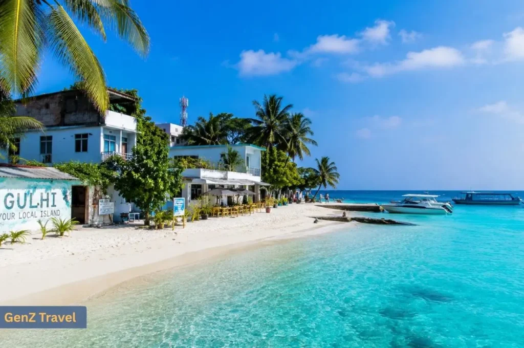 Quiet white-sand beach, local guesthouses and boats on Gulhi Island in the Maldives