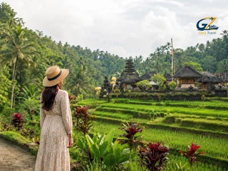 Traveller overlooking rice terraces and a traditional temple, highlighting the best things to do in Bali Indonesia.