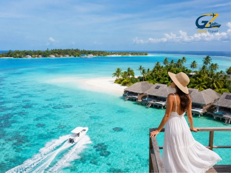 A Woman overlooking turquoise lagoon, speedboat and overwater villas at one of the best places to visit in Maldives