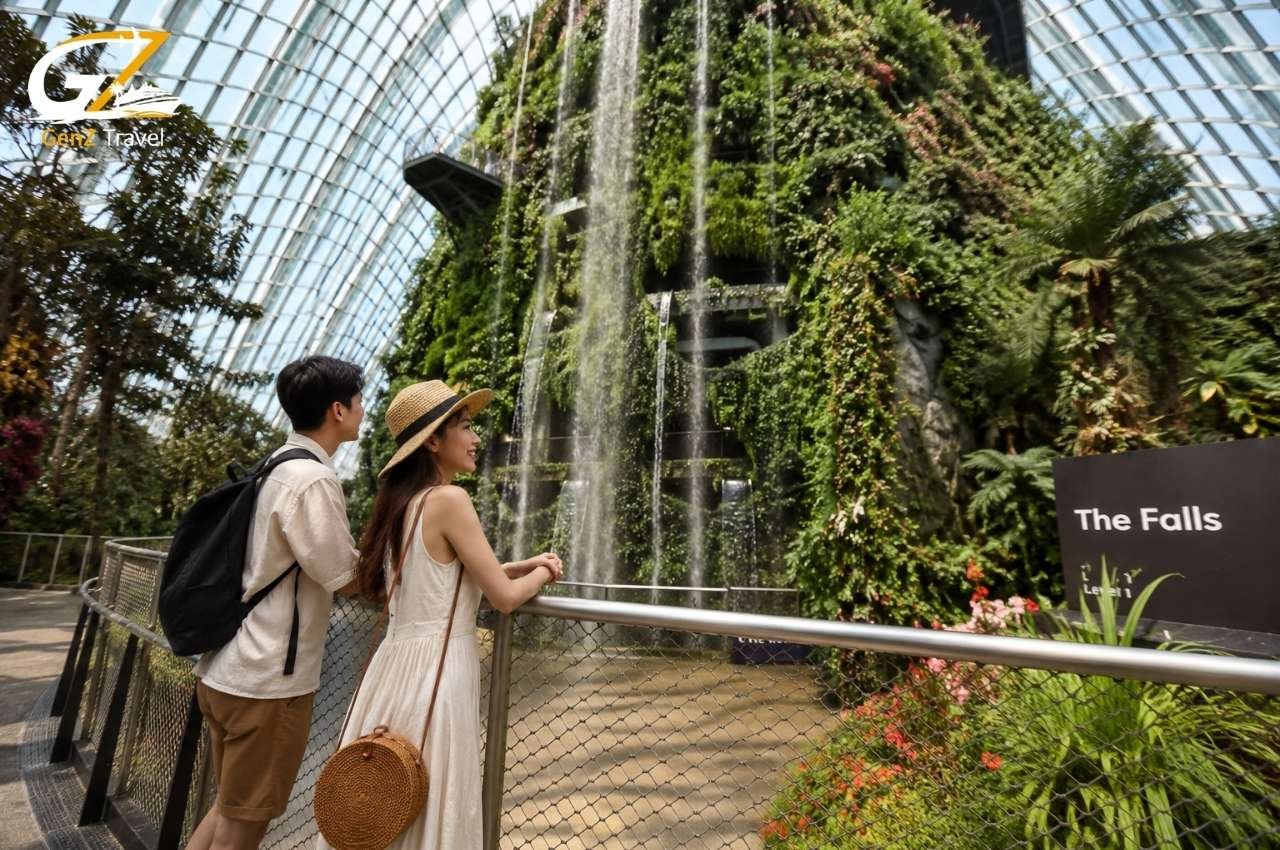 Couple admiring the Cloud Forest waterfall, one of the best things to do in Singapore.