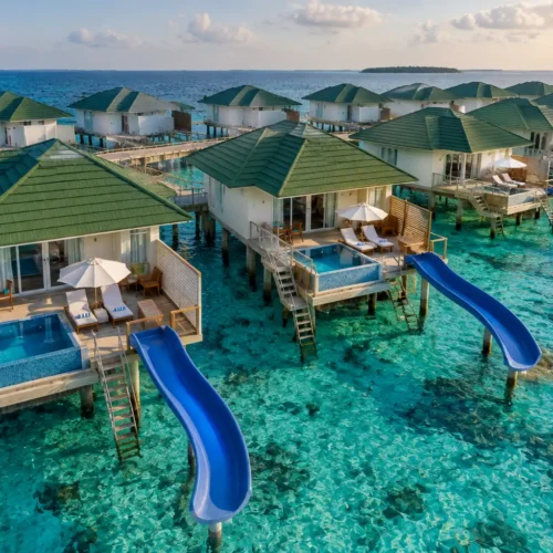 Luxury Maldives water villa resort featuring private slides, overwater bungalows, turquoise ocean and tropical island views