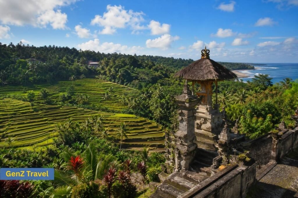 Balinese temple overlooking green rice terraces and tropical coastline in Bali