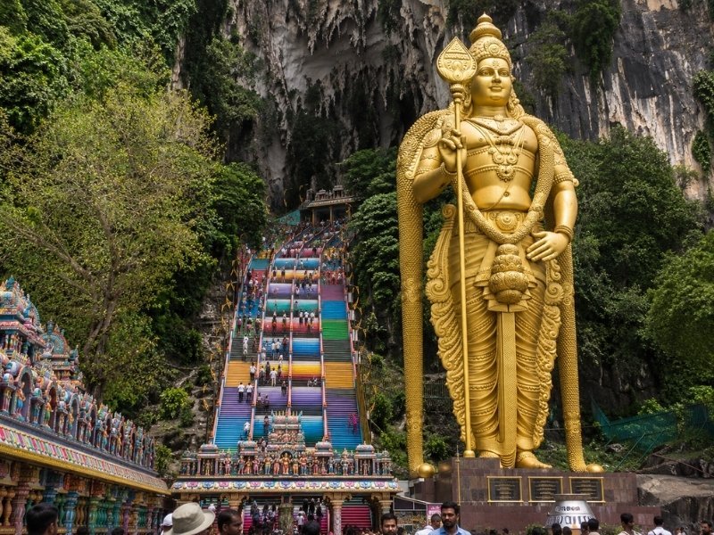 Golden Lord Murugan statue and colourful staircase at Batu Caves in Malaysia