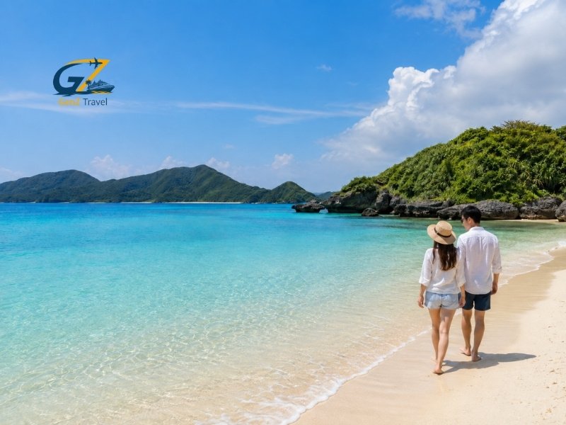 Couple walking along one of the best beaches in Japan with clear turquoise water, white sand and green coastal hills