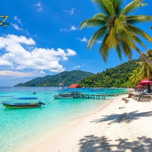 Tropical beach in Malaysia with turquoise water, white sand, palm trees and traditional boats
