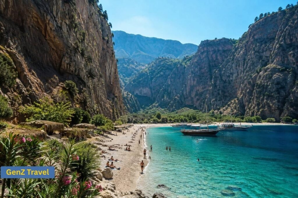 Butterfly Valley Beach beneath towering cliffs with turquoise water, visitors and traditional excursion boats