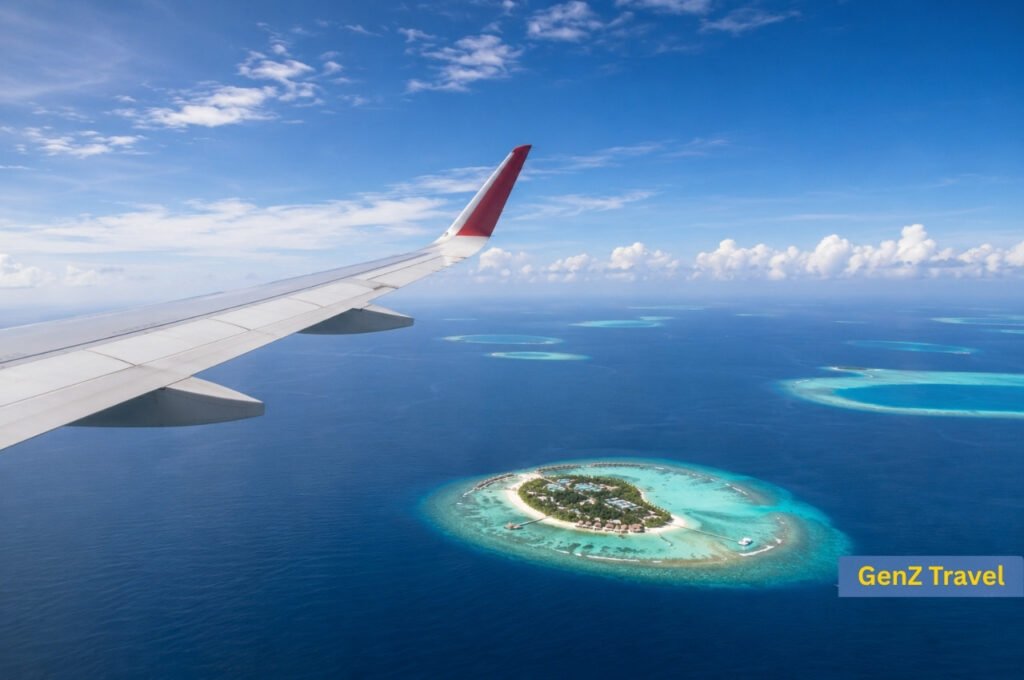 View from an aircraft wing over turquoise Maldives atolls during a flight from the UK