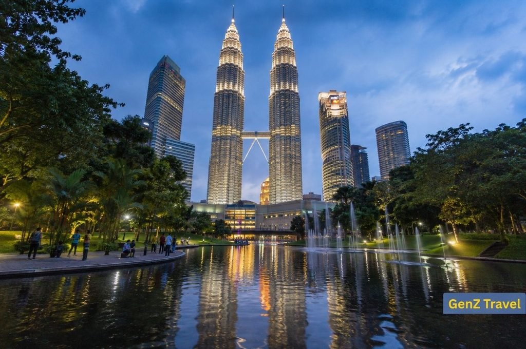 Illuminated Petronas Twin Towers reflected in KLCC Park, Kuala Lumpur