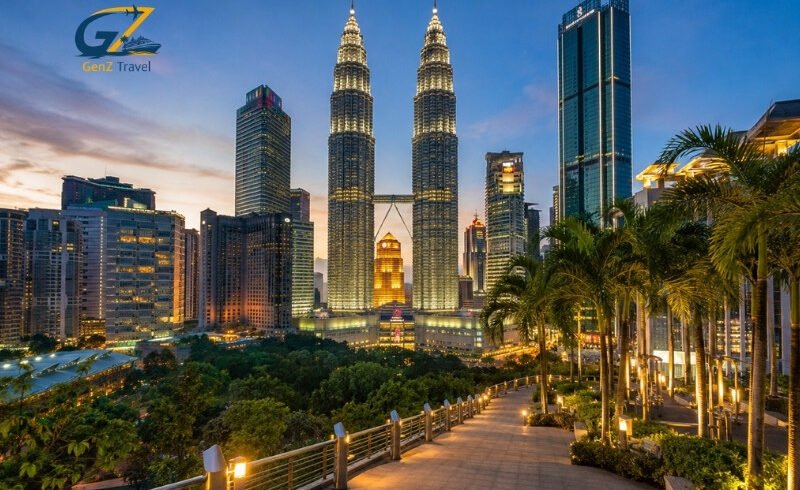 Kuala Lumpur skyline at sunset with the illuminated Petronas Twin Towers and landscaped city surroundings