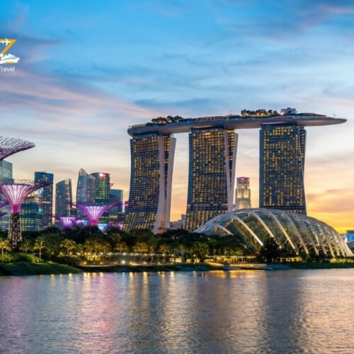 Marina Bay Sands and Gardens by the Bay illuminated at sunset across Singapore’s waterfront